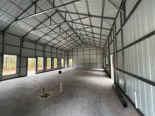 Interior of a long steel building with windows