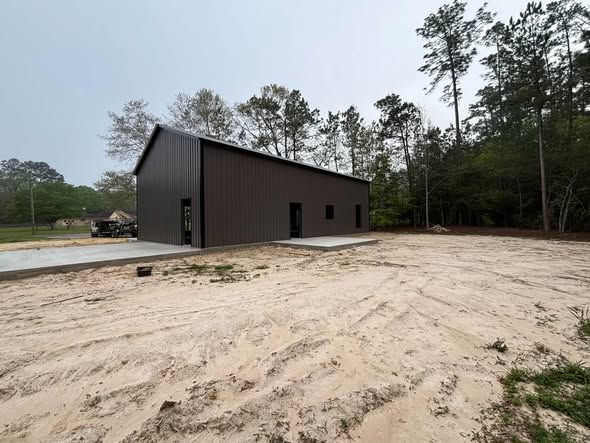 Dark steel building in a wooded lot